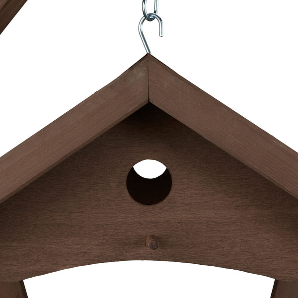 Bruin hangend vogelvoederhuisje muur