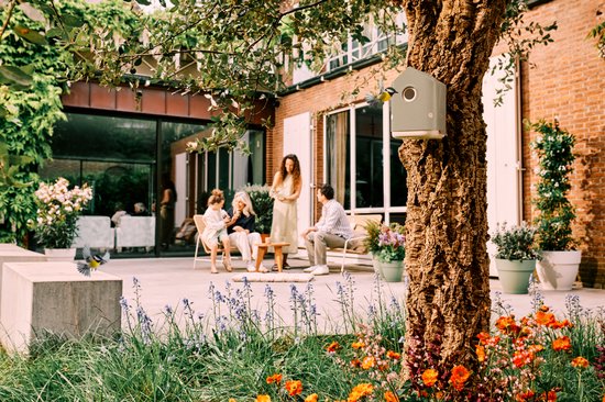 Cosy vogelhuisje beige bij terras in de tuin