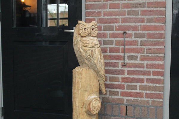 Wooden sculpture owl on trunk